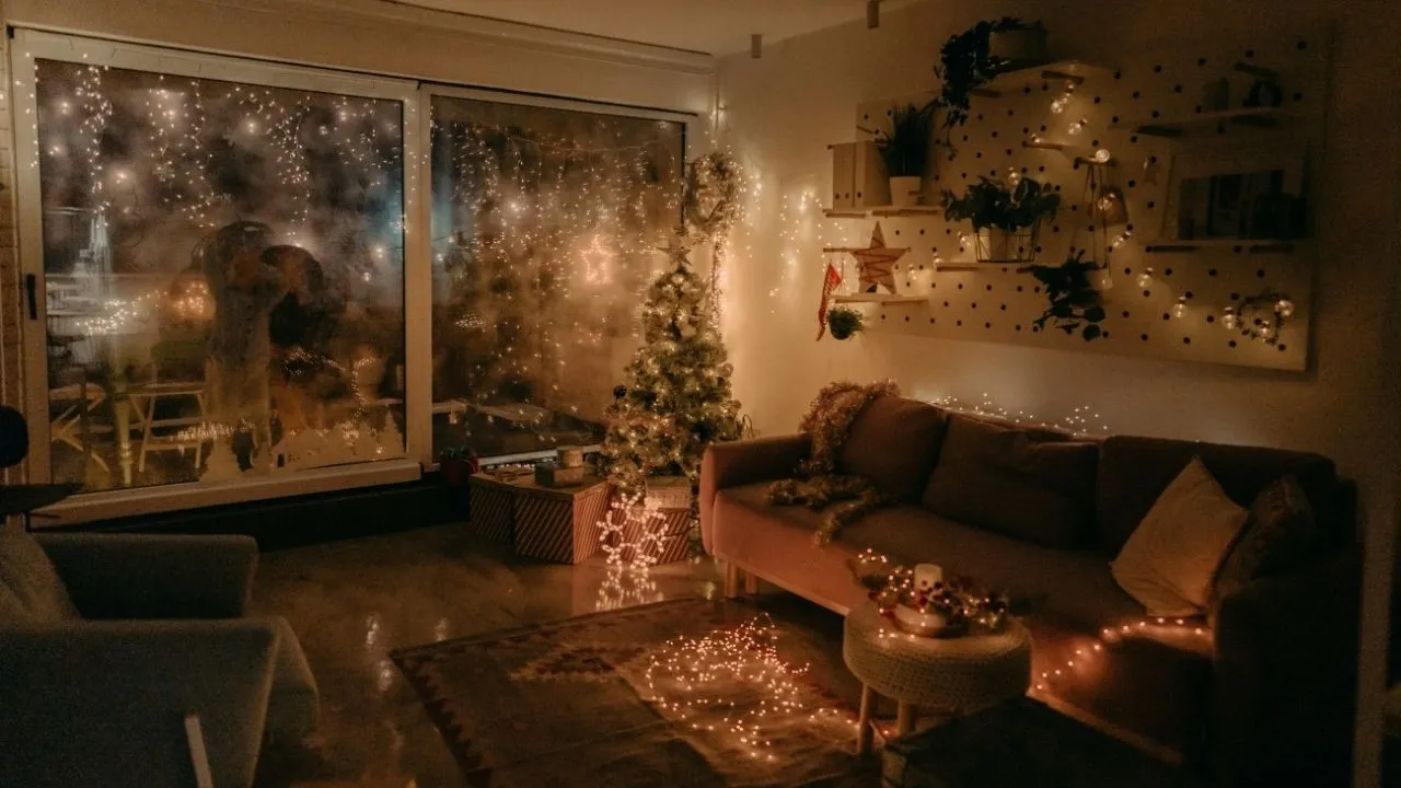 Útulný obývací pokoj s teplým světlem a přírodními dekoracemi vystihuje moderní, udržitelné Vánoce 2025